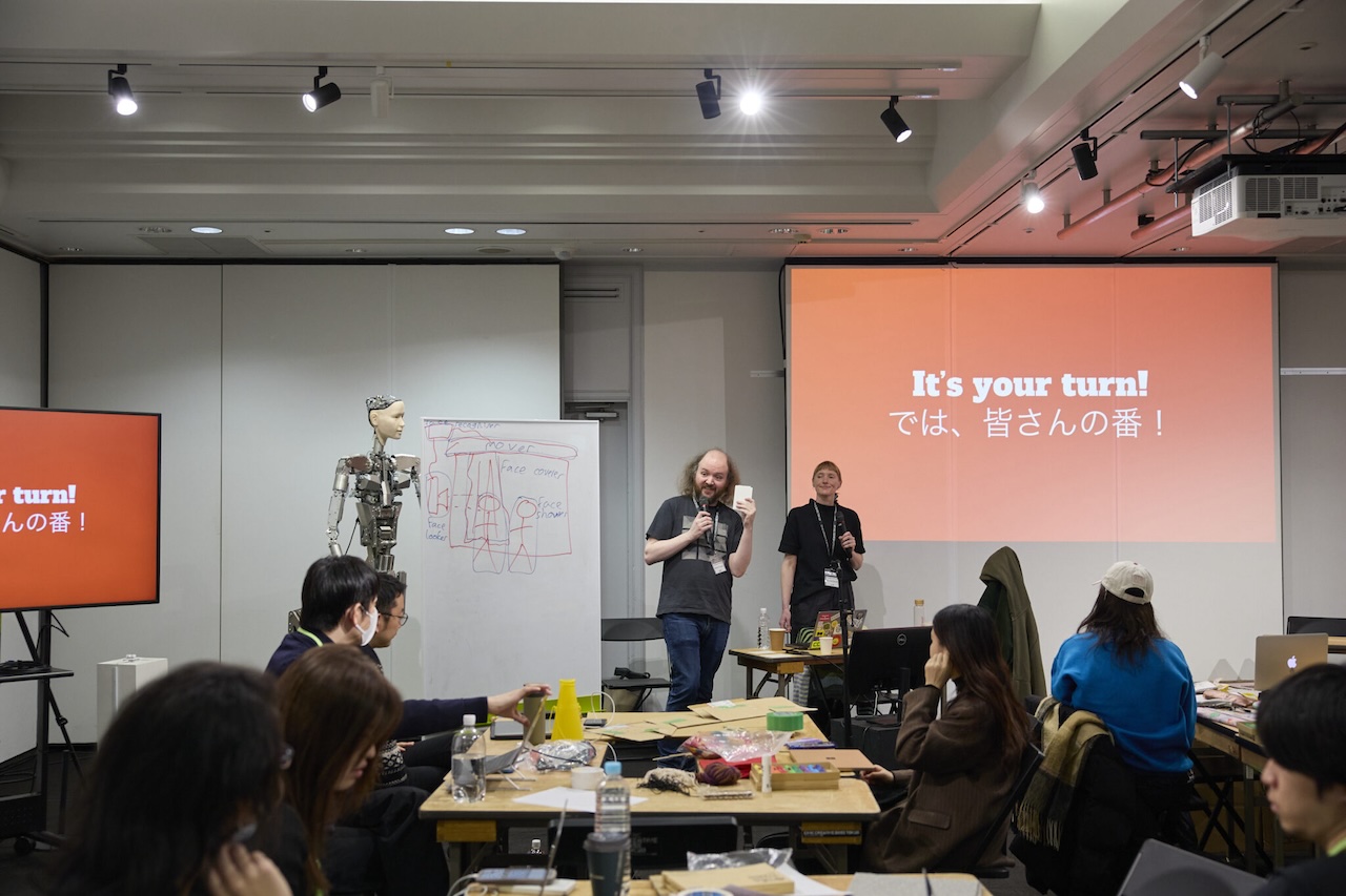 me standing in front of a room full of Japanese people and also a weird robot