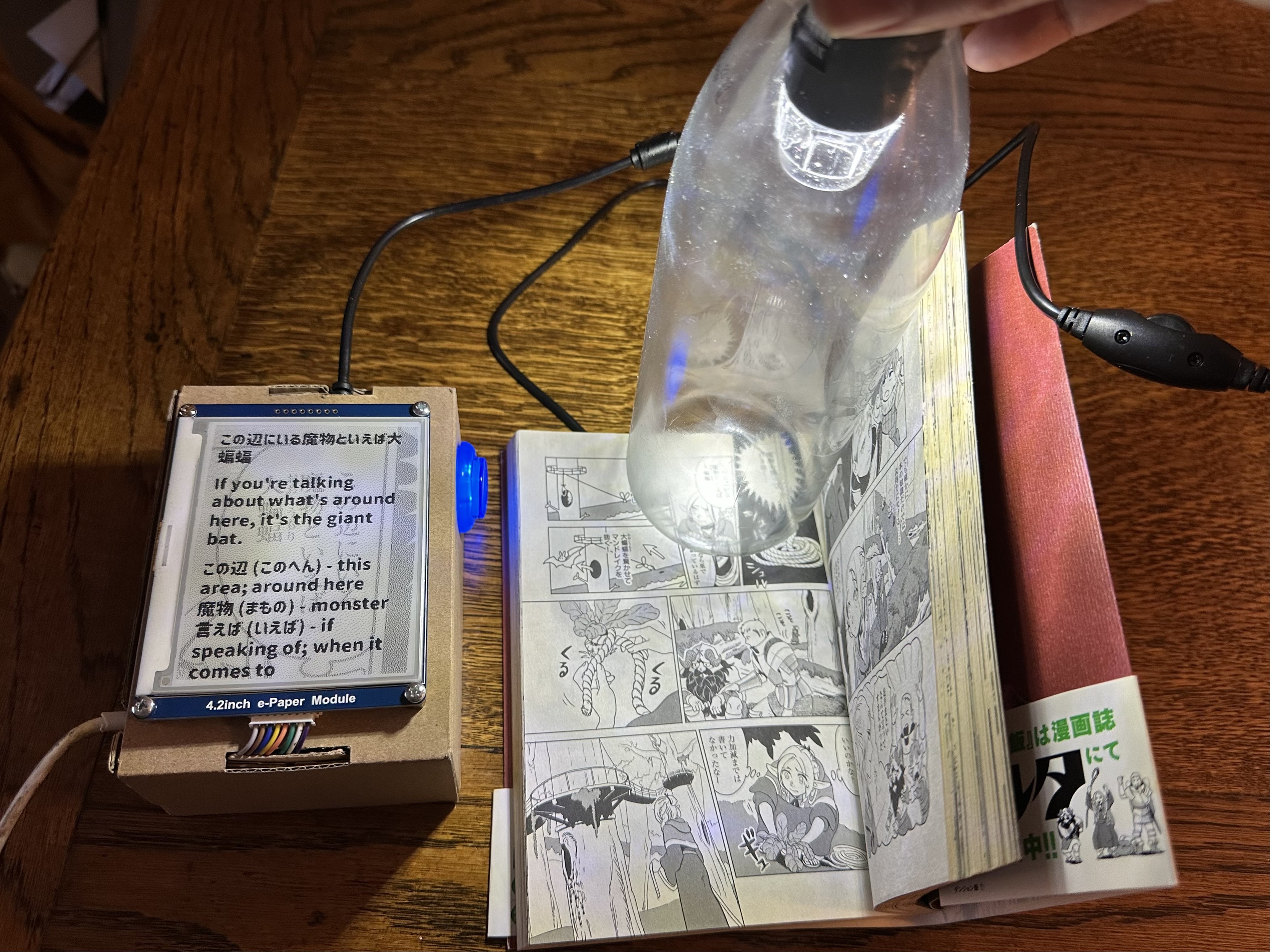 a USB microscope pointing at a volume of manga